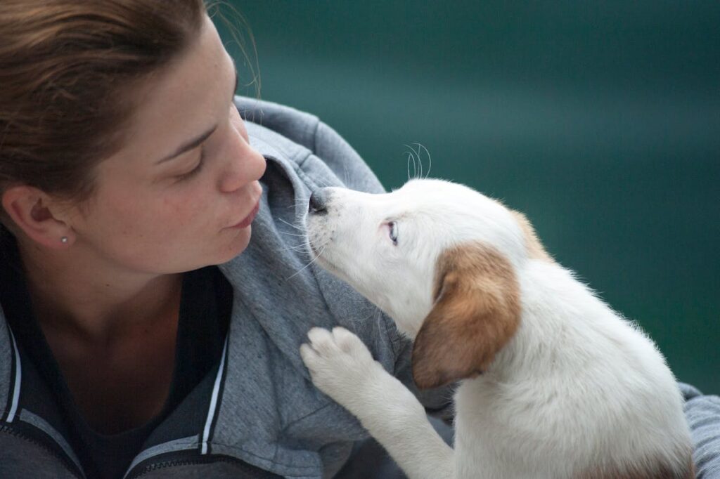 pexels-photo-1174081 A candid shot of a woman and puppy sharing a tender moment outdoors.